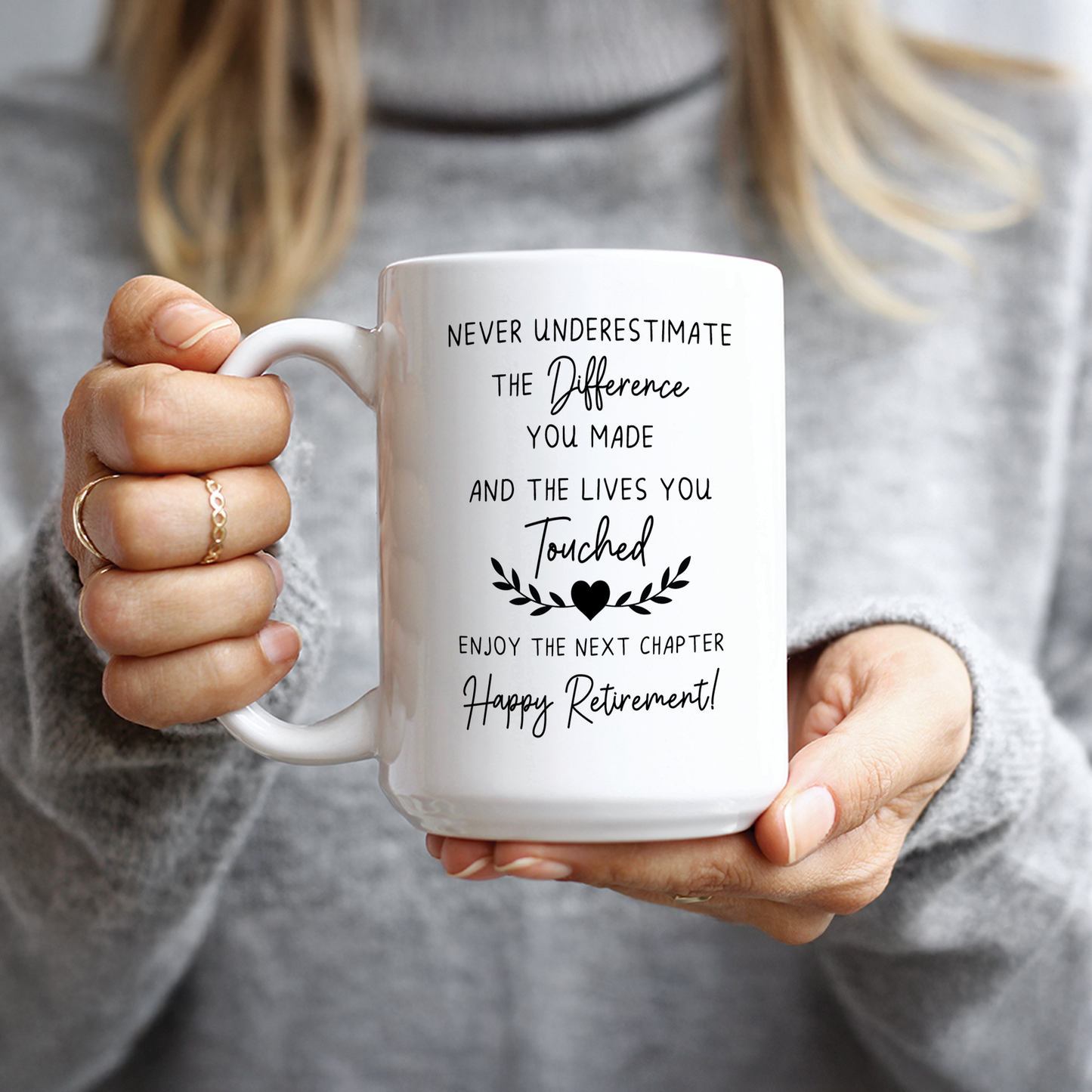Woman in grey sweater holding heartfelt teacher or nurse retirement gift mug