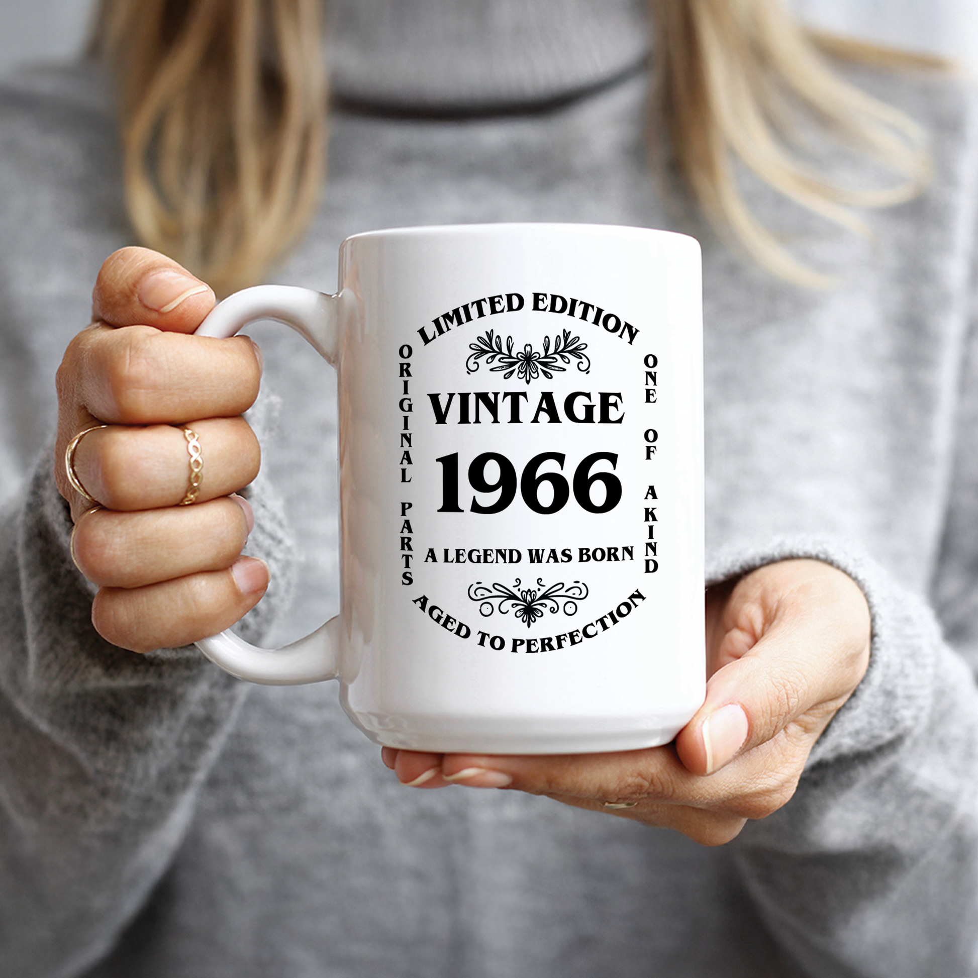 Woman in grey sweater holding relatable milestone 60th birthday gift mug