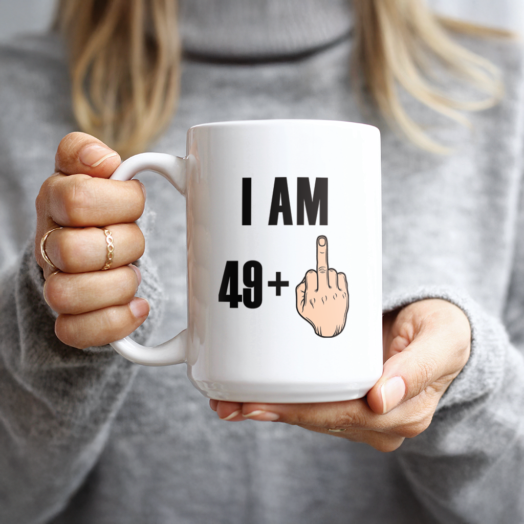 Hand holding white mug with I Am 49 Plus One design