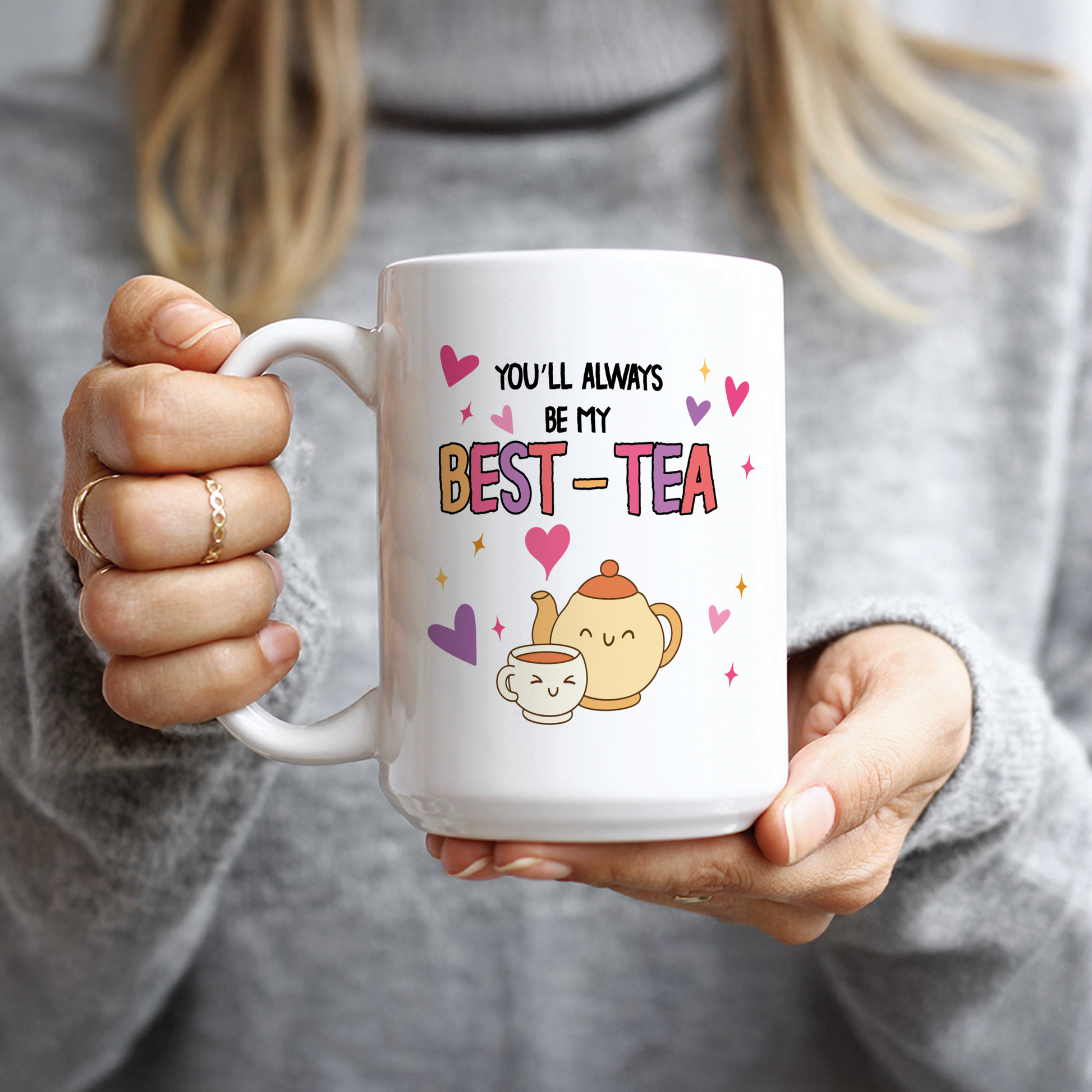 Hand holding funny Best-Tea mug with smiling tea cup cartoon
