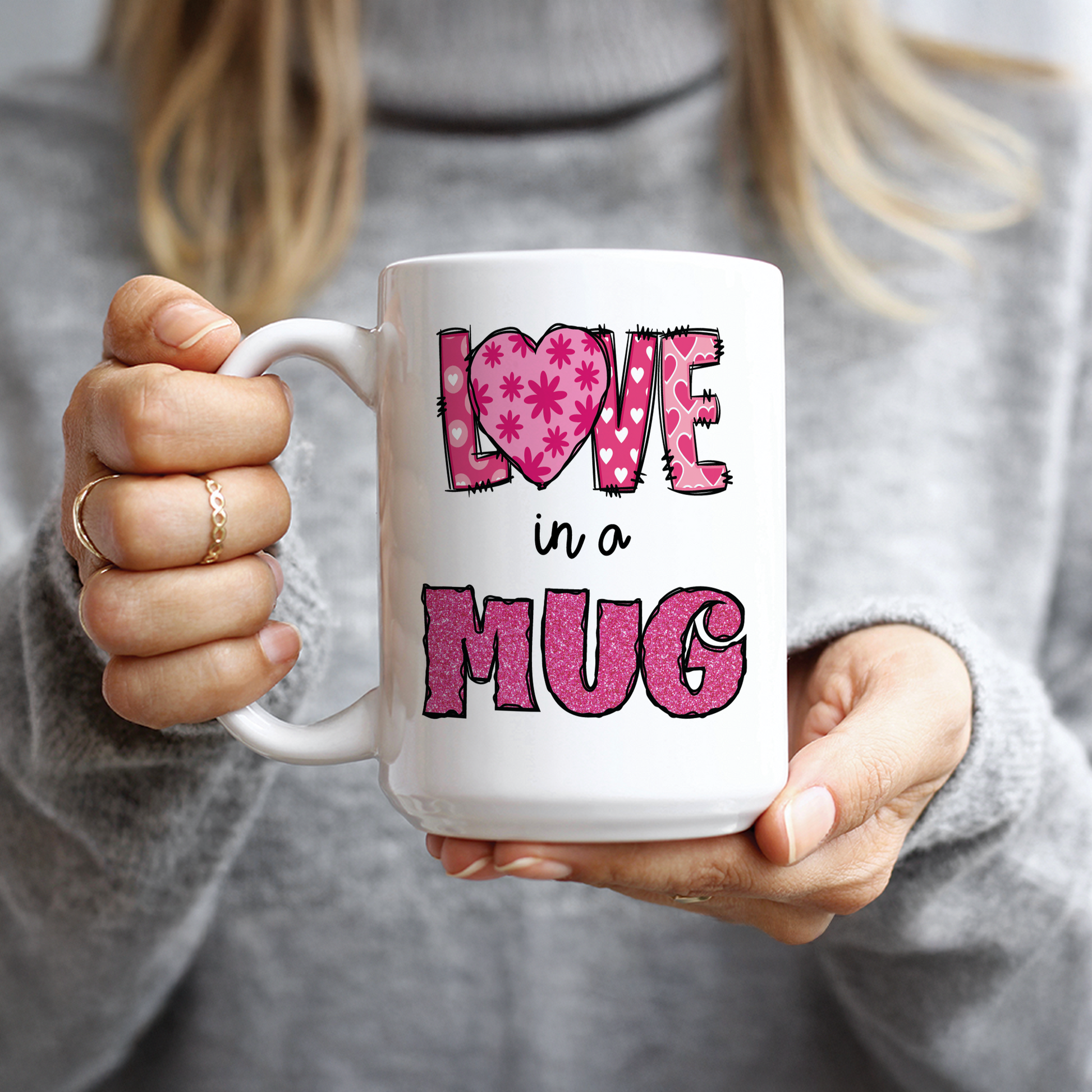 Hand holding white mug with pink glitter Love in a Mug design