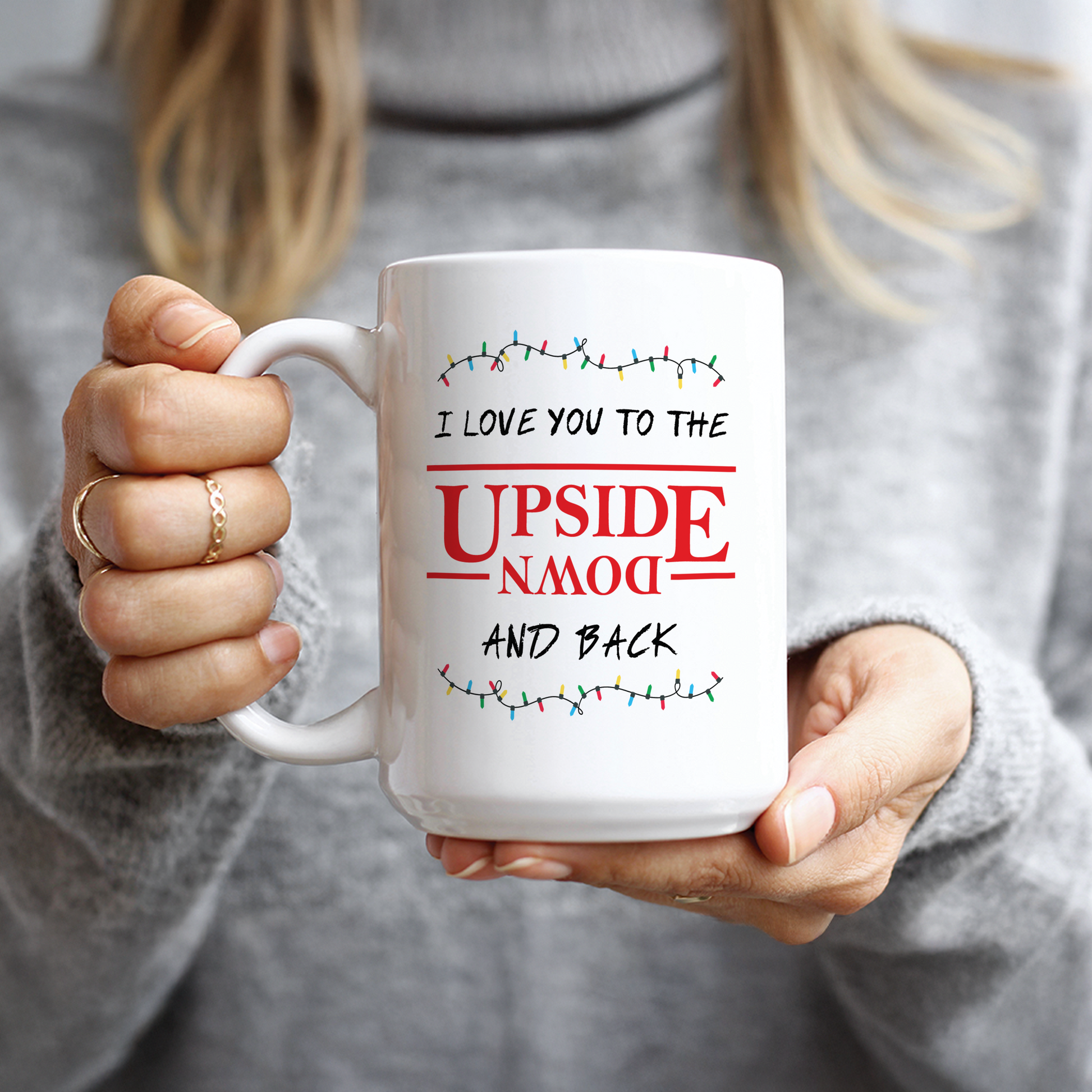Hand holding 15oz mug with red and black forest design
